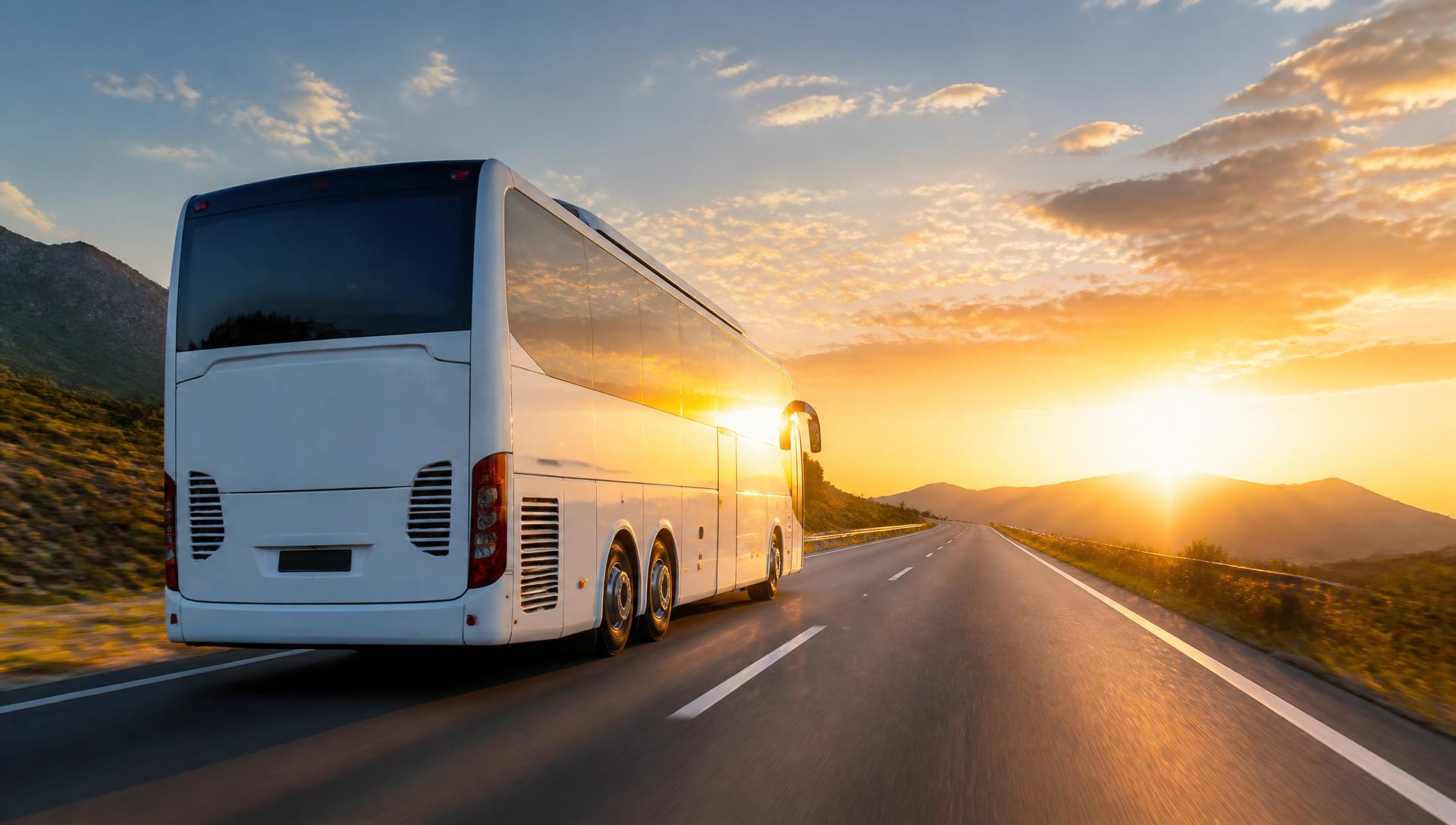Coach travelling toward a bright horizon on an open highway