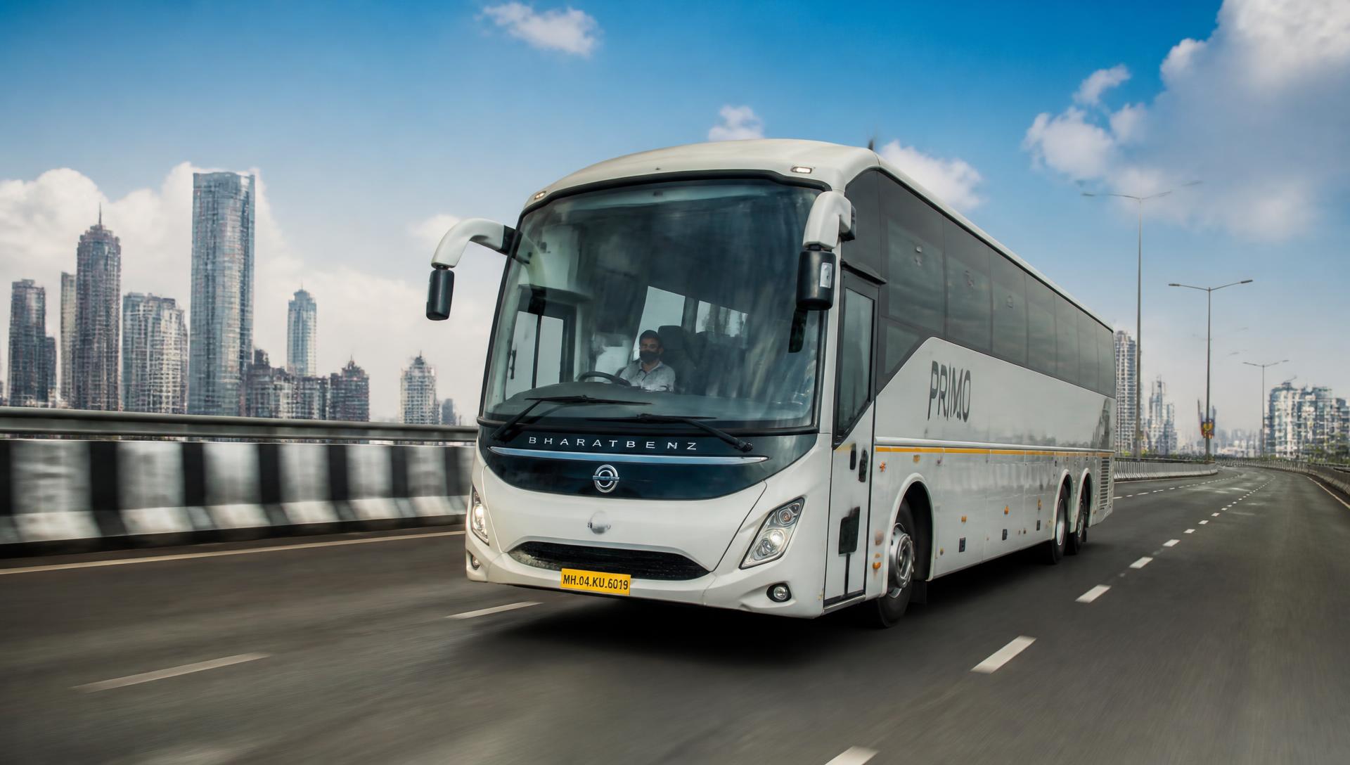 Coach travelling on a Mumbai highway with the city skyline behind